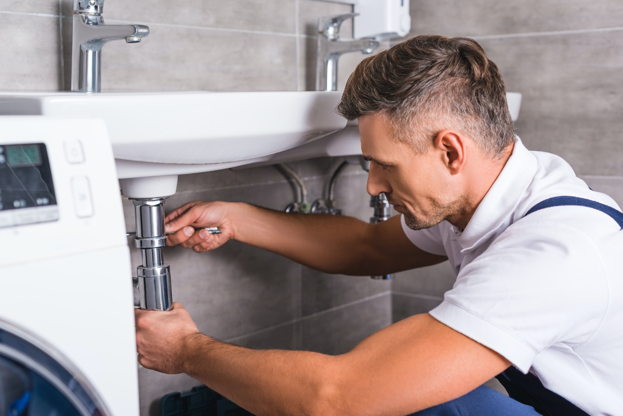 adult-plumber-fixing-sink-at-bathroom.jpg